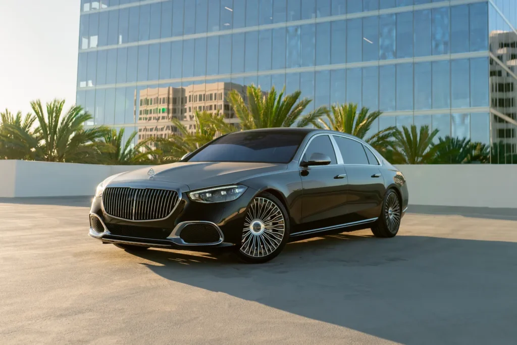 Black Mercedes-Maybach S580 from Monza Exotics parked on a rooftop in front of a glass office tower