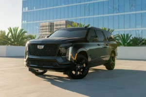Black Cadillac Escalade ESV Platinum from Monza Exotics parked on a rooftop in front of a glass office tower