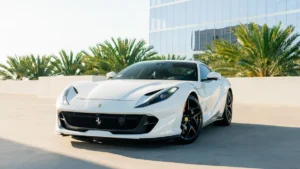 White Ferrari 812 Superfast from Monza Exotics parked on a rooftop in front of glass office towers